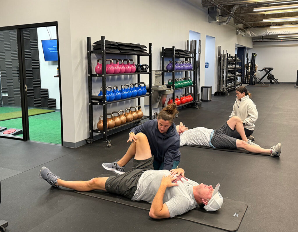 Two men receiving a golf fitness assessment from personal trainers